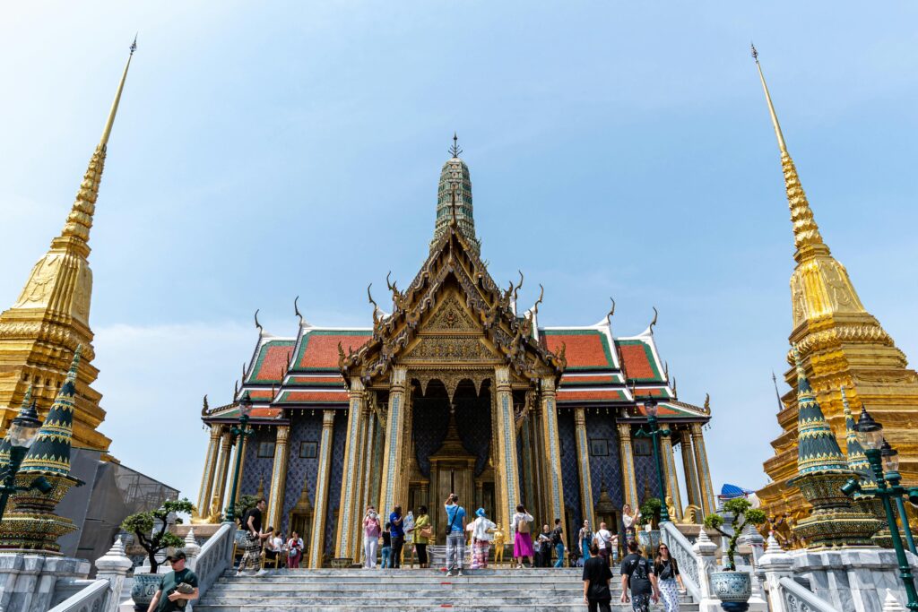 Visitors at the iconic Wat Phra Kaew temple in Bangkok, showcasing vibrant architecture and cultural heritage.